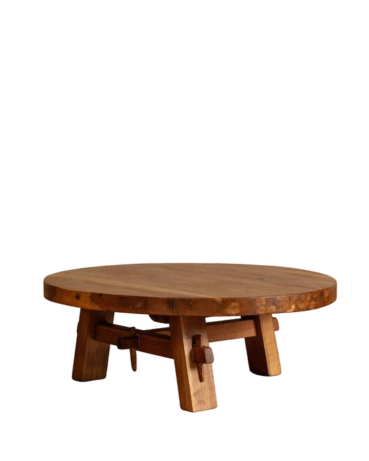 Wooden round table on a wooden floor with a beige wall background