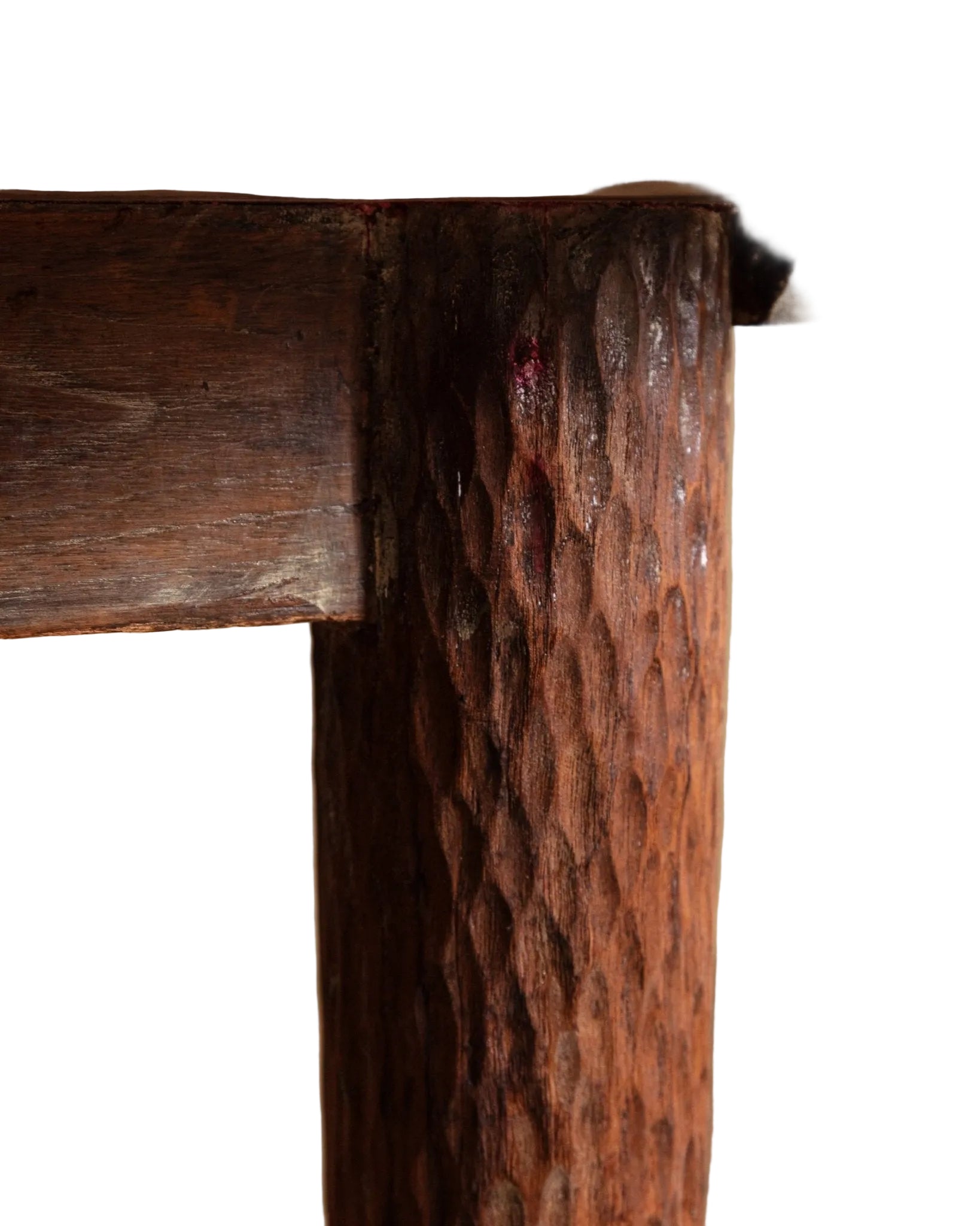 Close-up of a wooden table with a textured leg against a neutral background