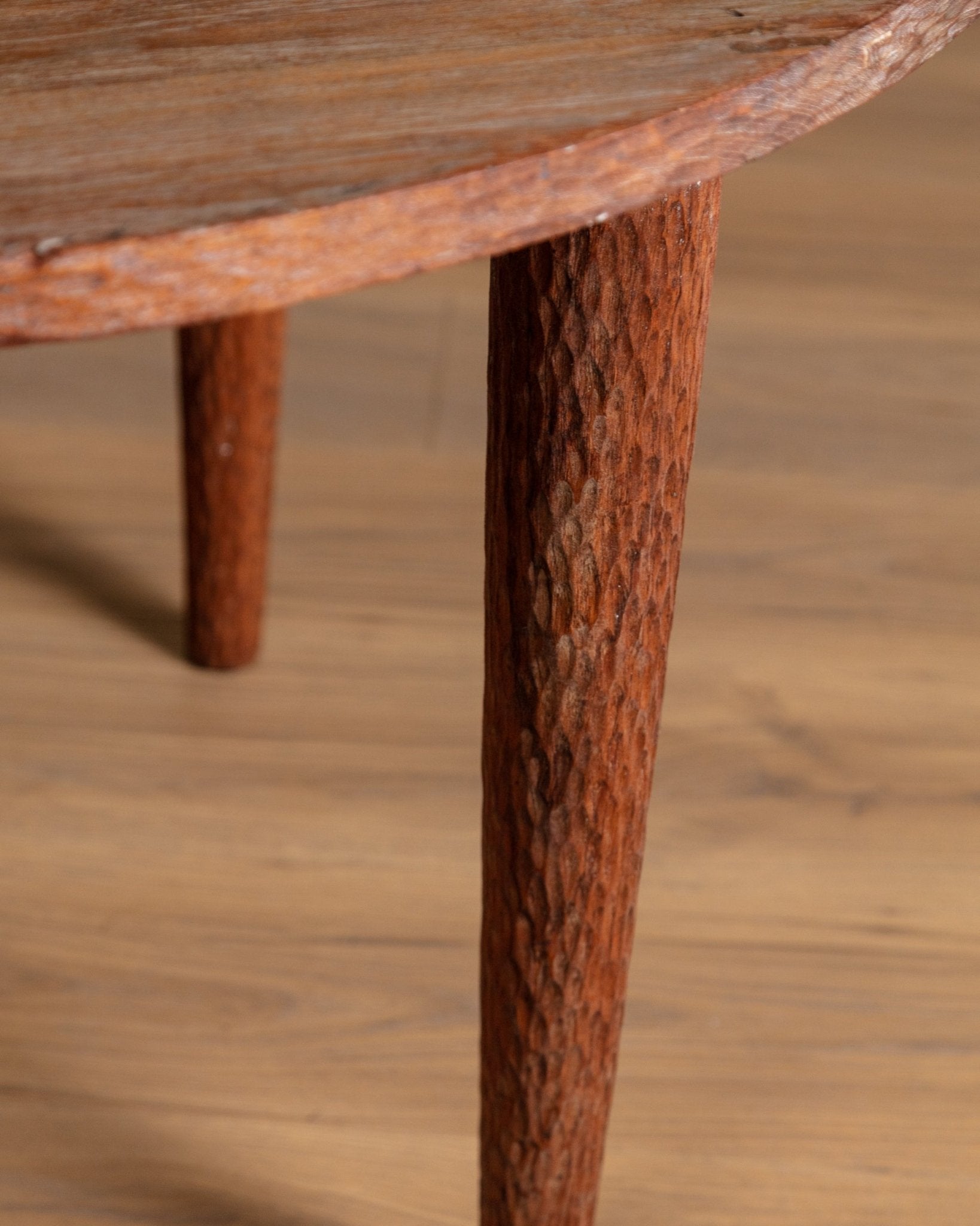 Close-up of a wooden table leg with a textured surface on a matching wooden background