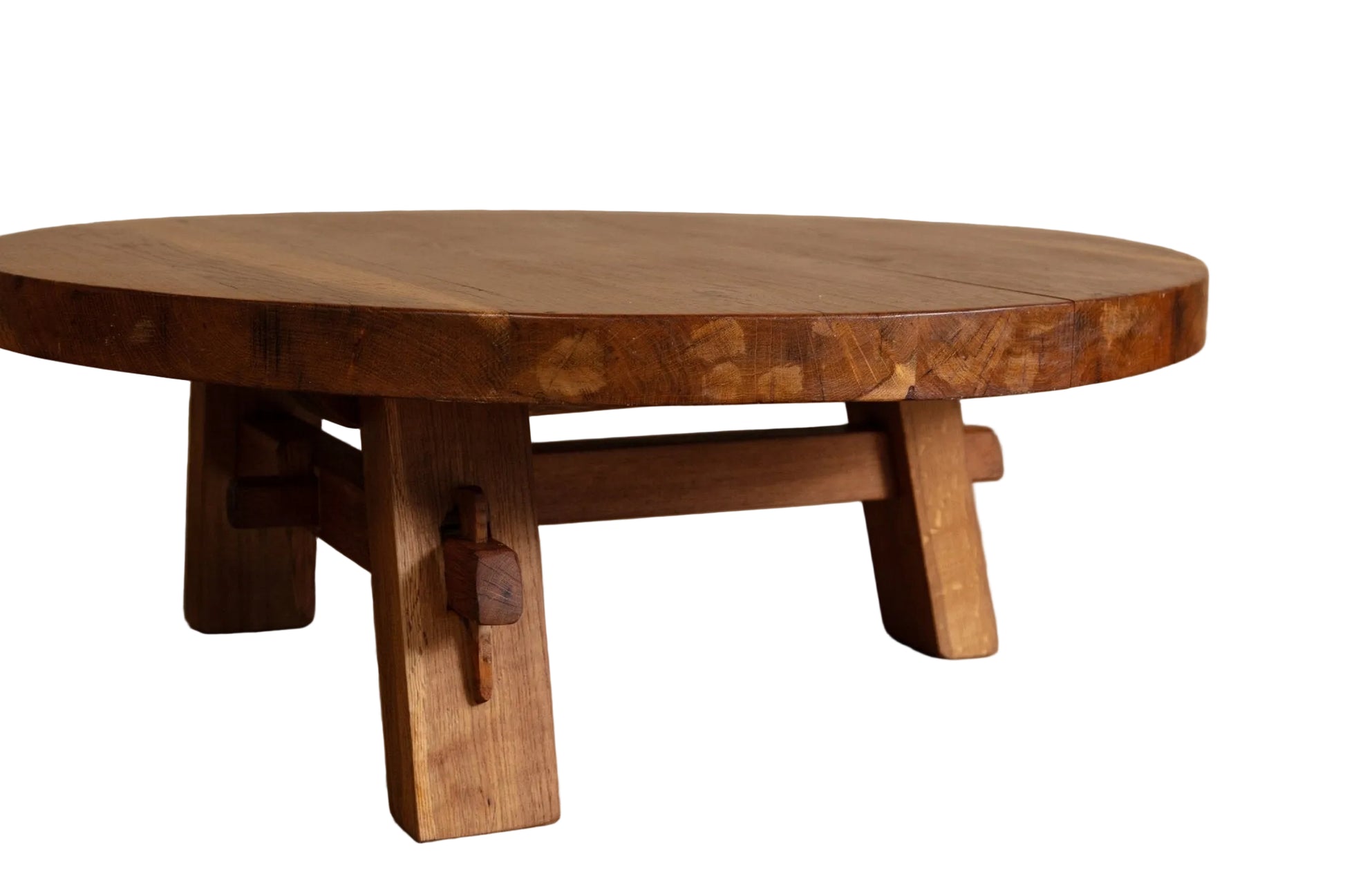 Wooden round table with rustic design on a wooden floor.