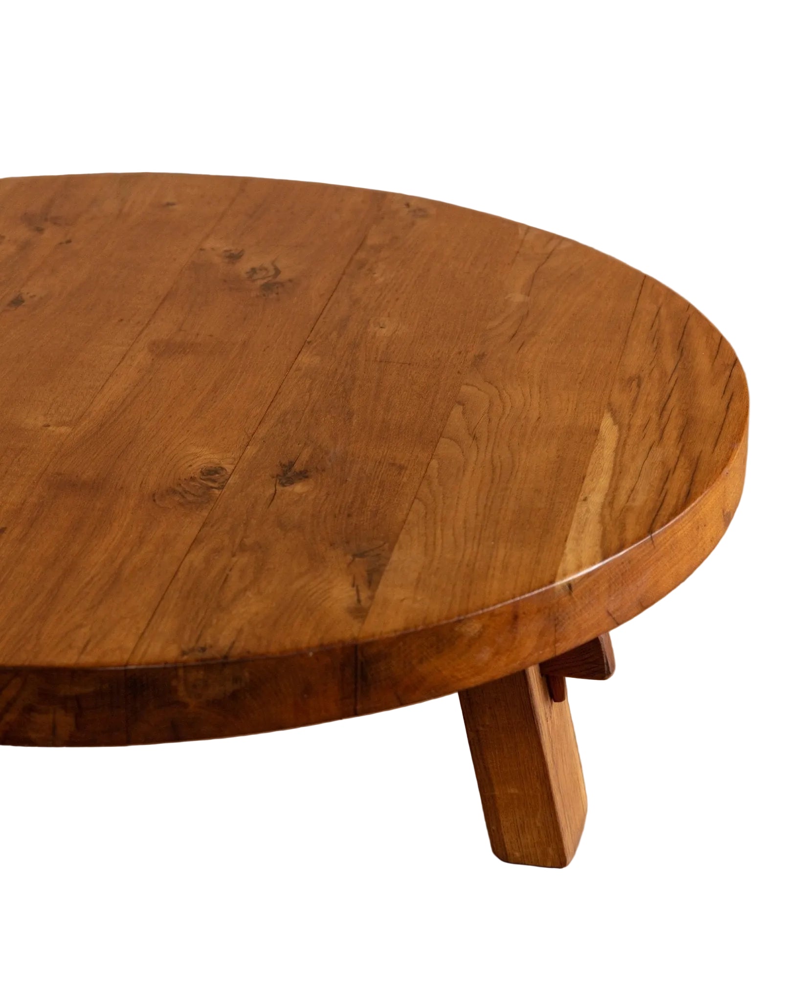 Round wooden table with a natural finish on a wooden floor.
