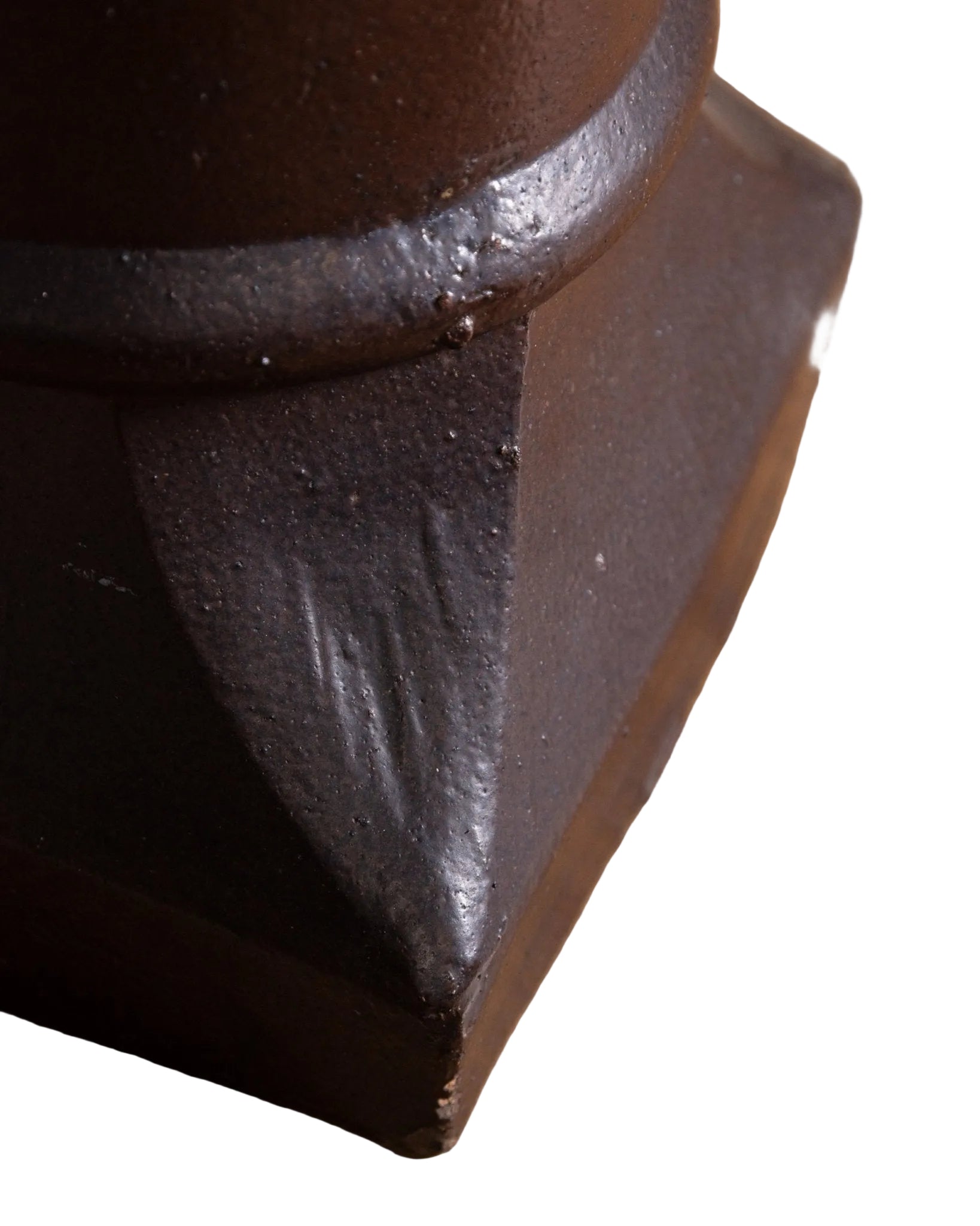 Close-up of a dark brown metal object on a wooden surface