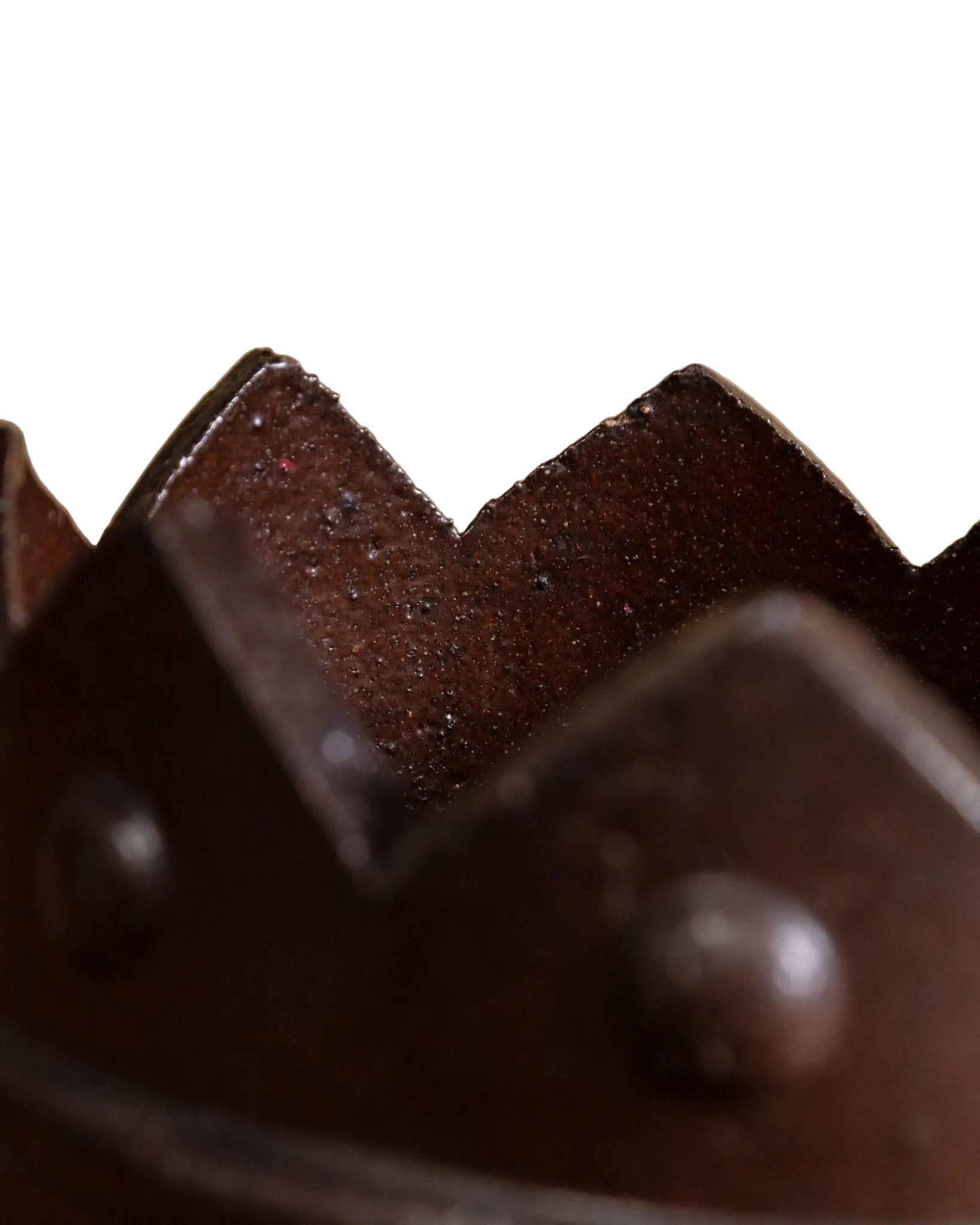 Close-up of a dark brown leather product with textured surface and metal rivets.