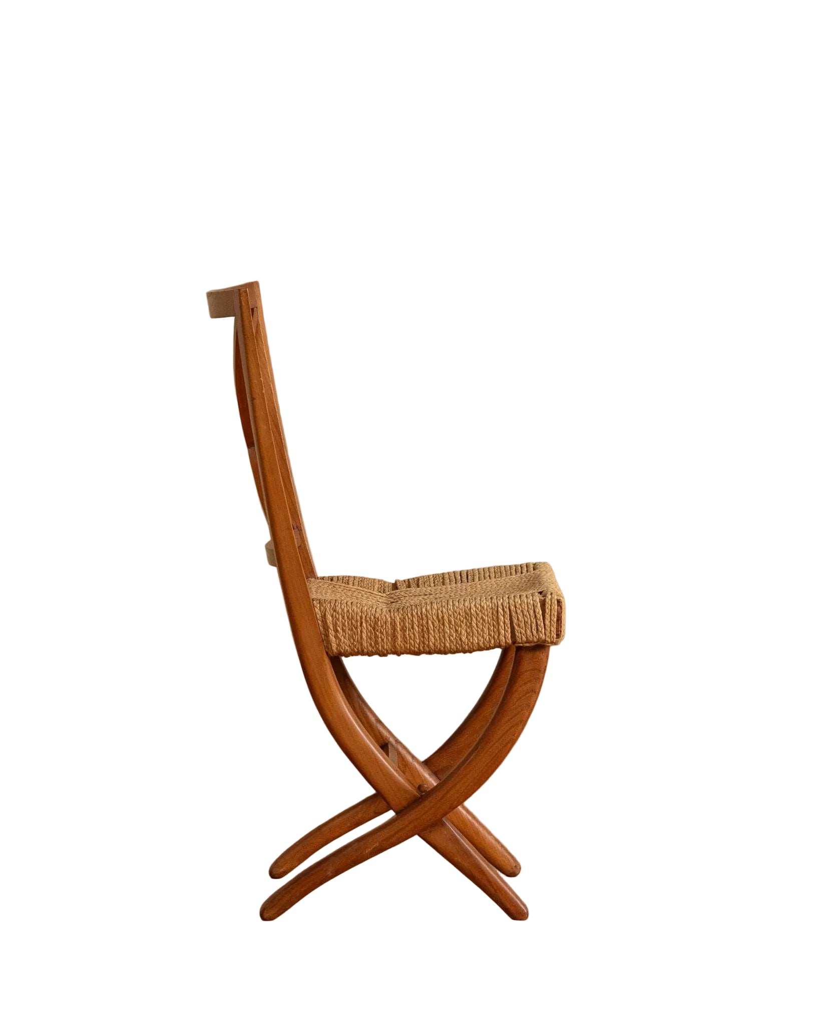 Wooden chair with woven seat against a beige wall