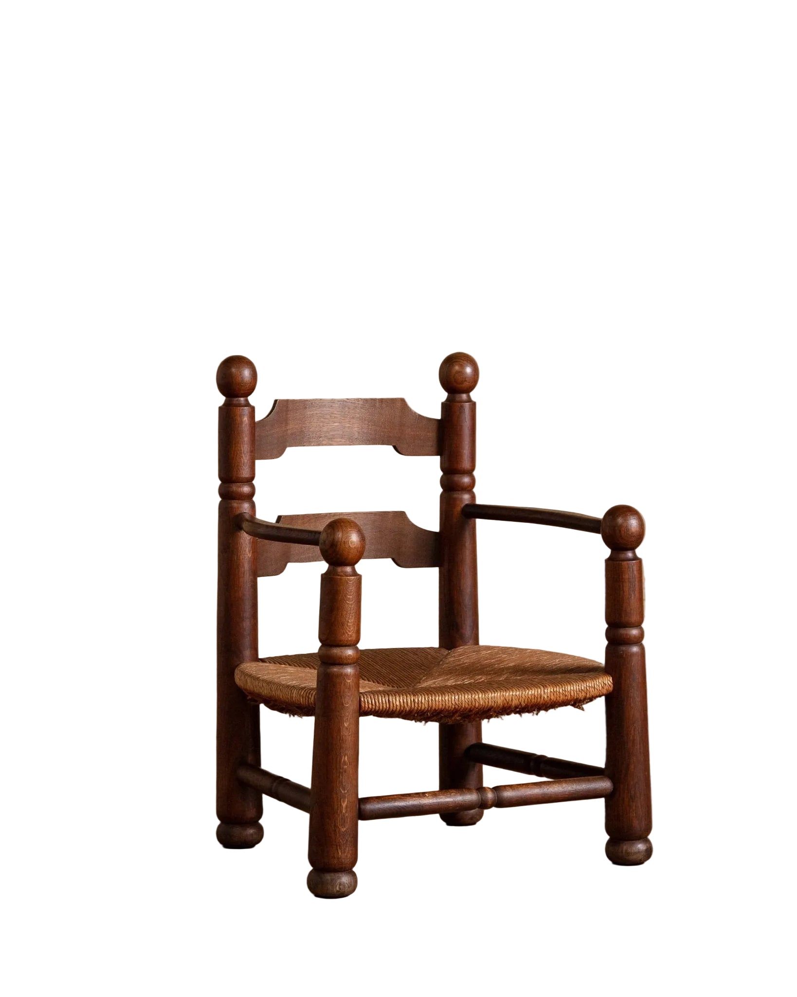 Wooden chair with a woven seat on a wooden floor against a beige wall