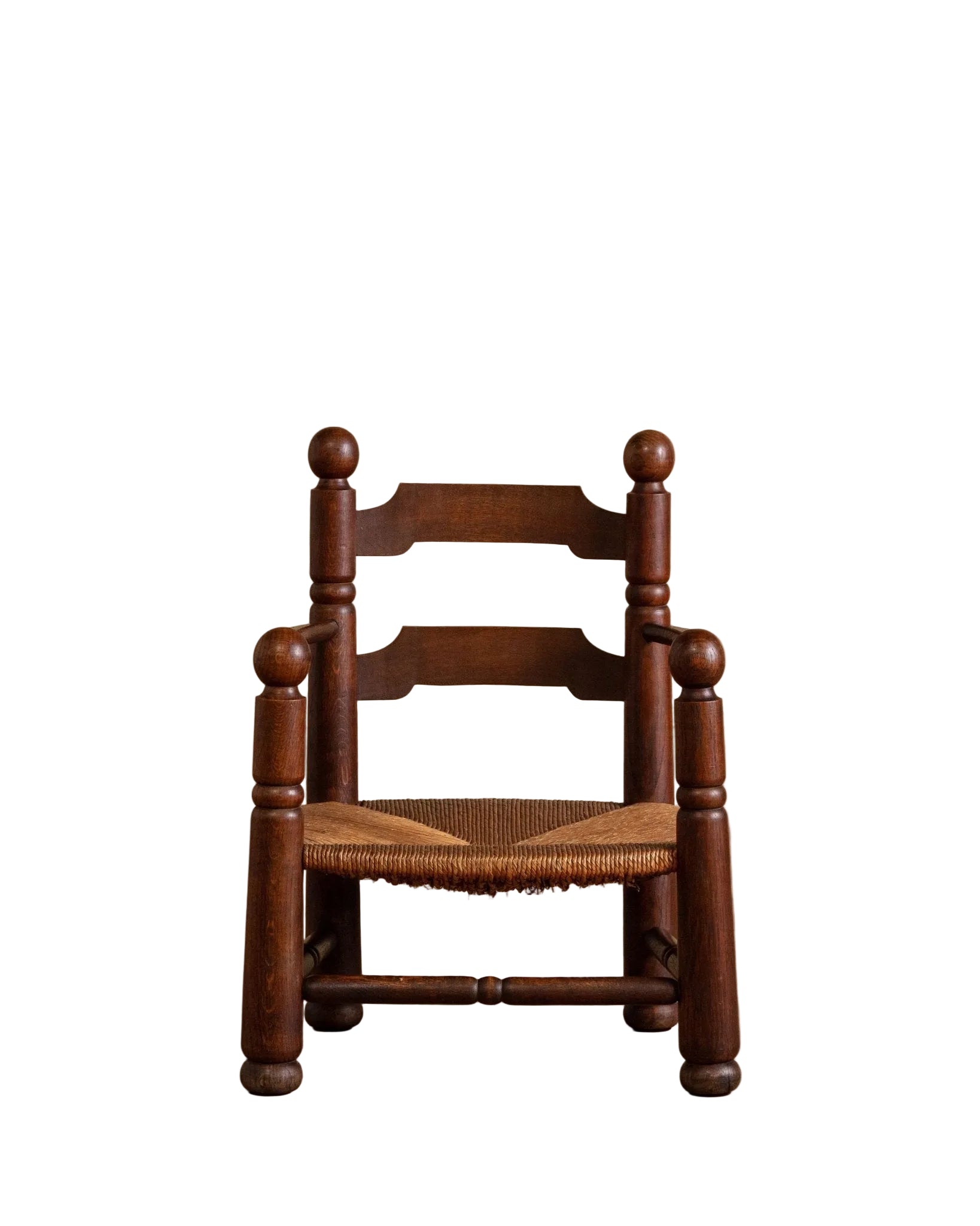 Wooden chair with woven seat on a wooden floor against a beige wall