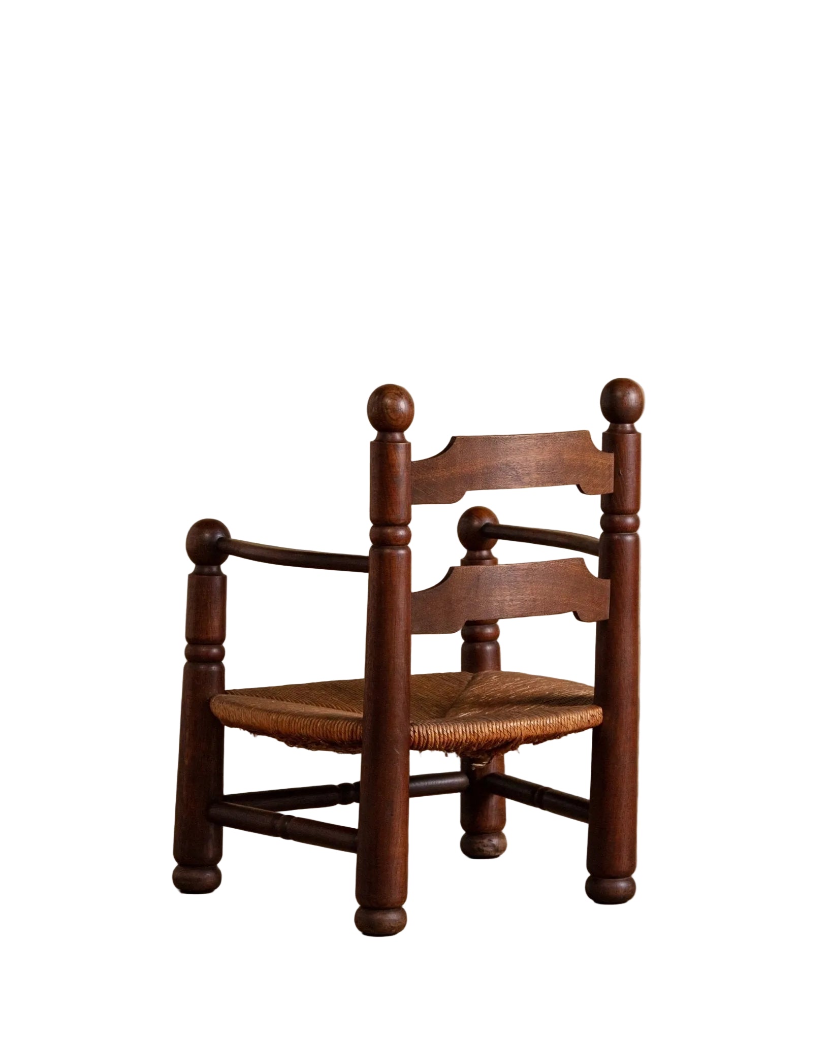 Wooden chair with a woven seat on a wooden floor against a beige wall