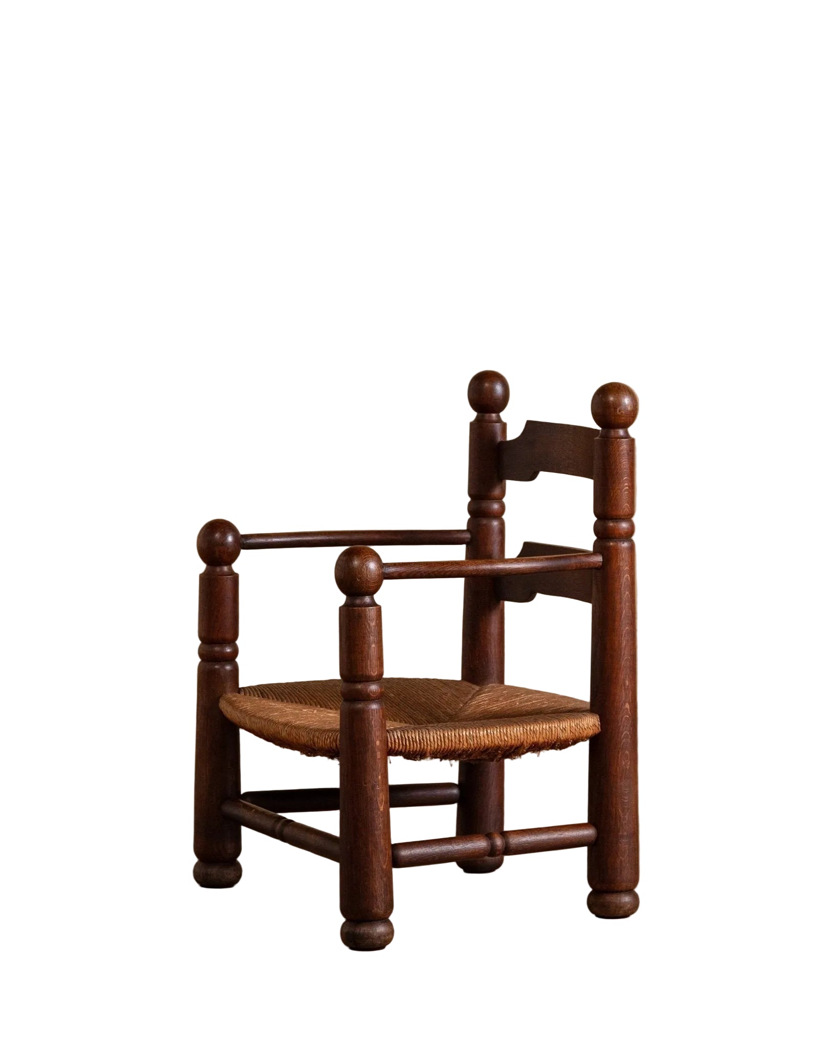 Wooden chair with woven seat on a wooden floor against a beige wall