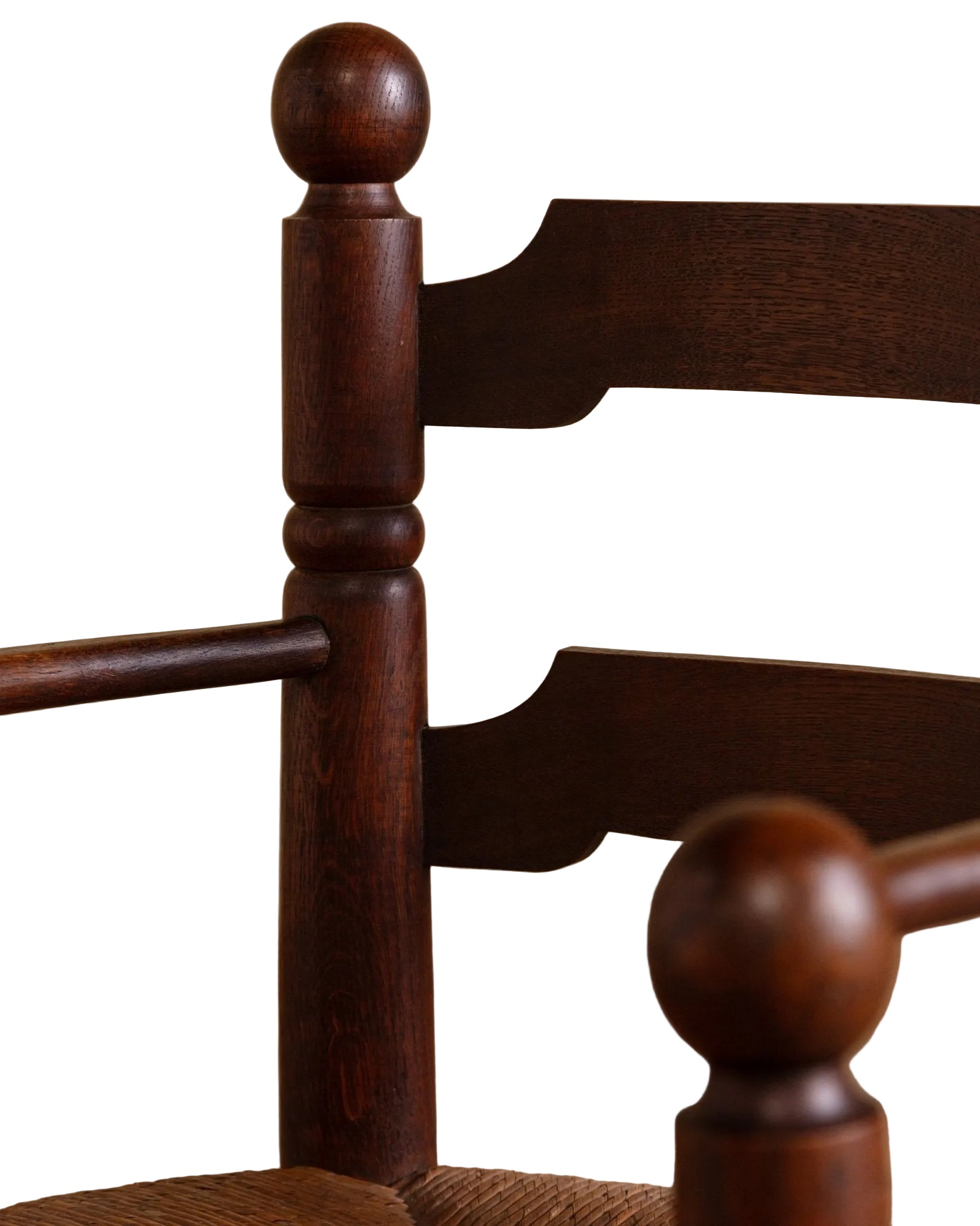 Close-up of a wooden chair with ball-shaped finials on a beige background