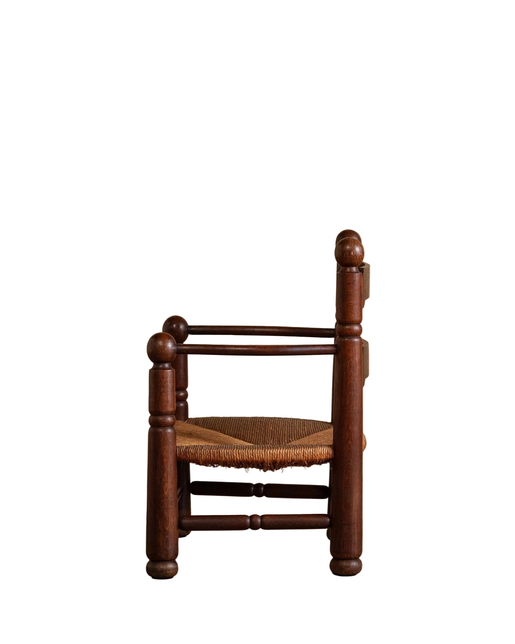 Wooden chair with a woven seat on a wooden floor against a beige wall