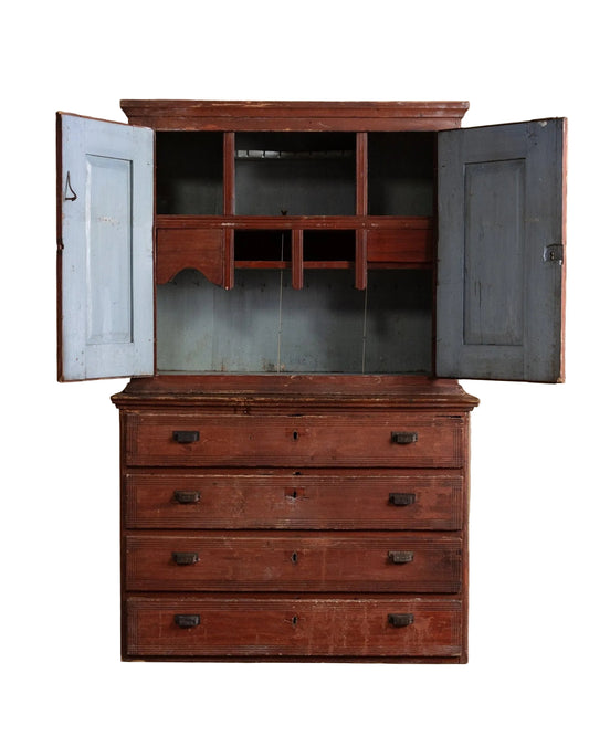 Wooden dresser with open doors on a wooden floor against a beige wall