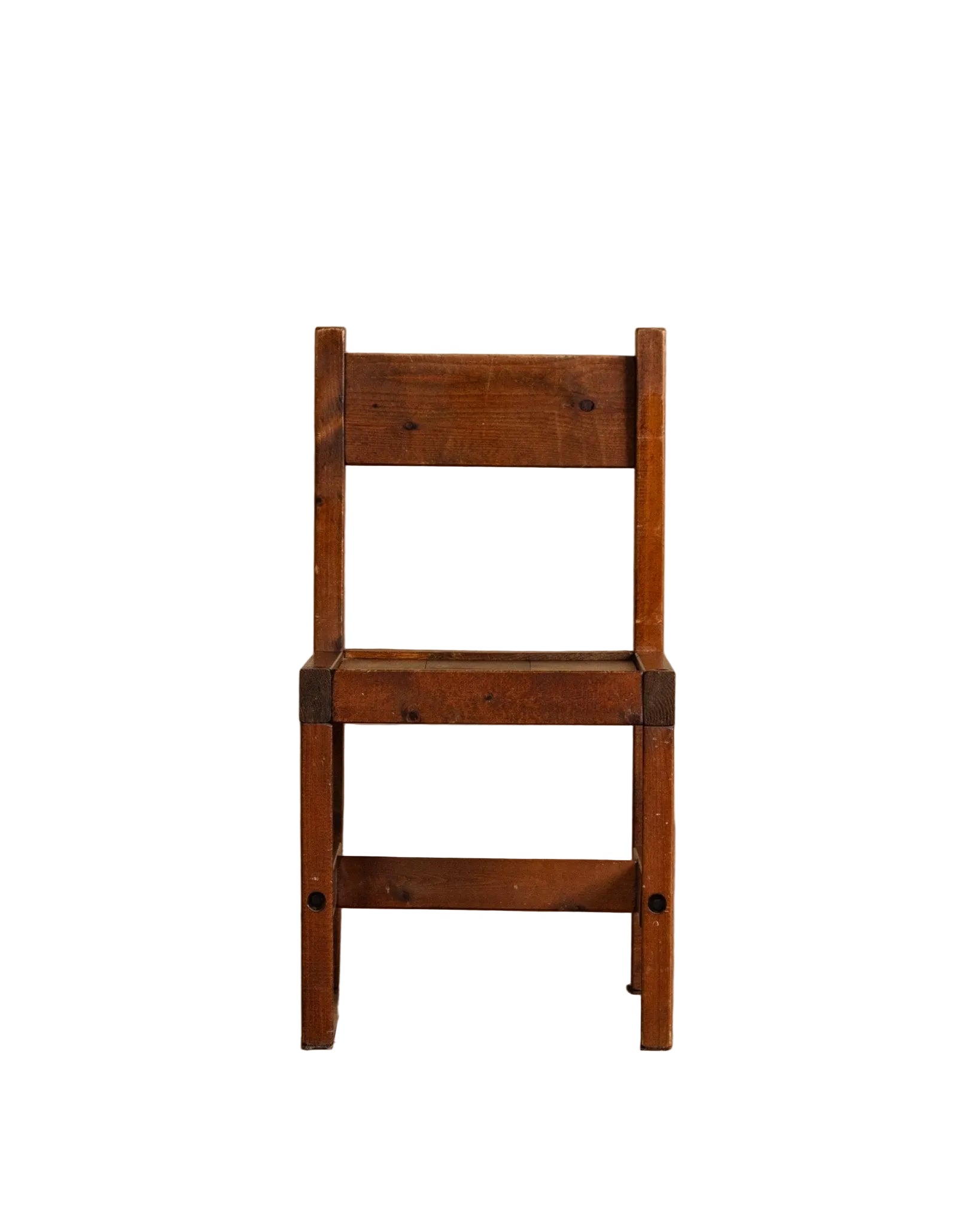 Wooden chair against a beige wall