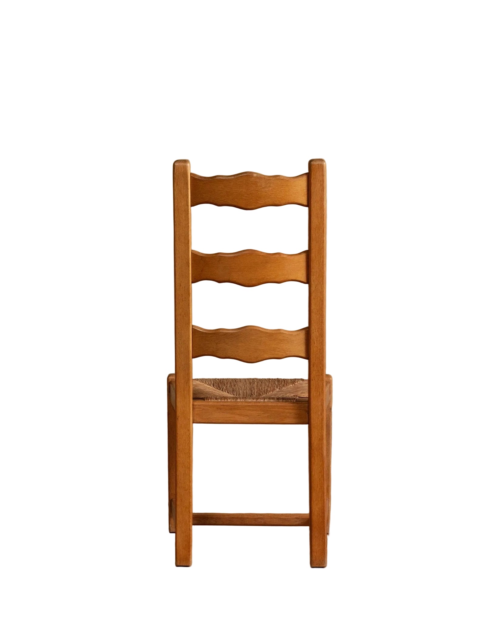 Wooden chair with woven seat on a wooden floor against a beige wall