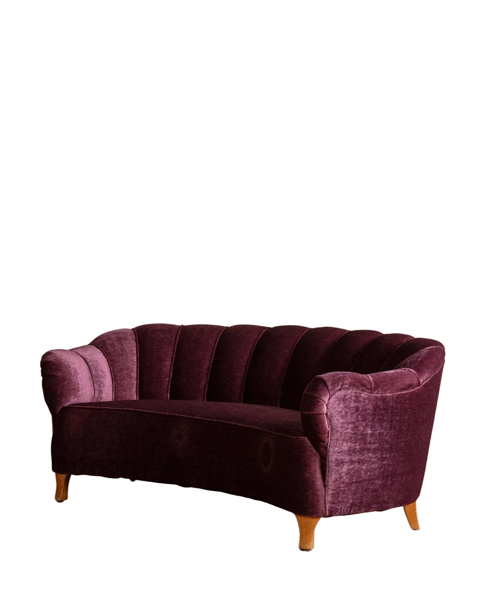 Purple velvet sofa on a wooden floor with a beige wall background