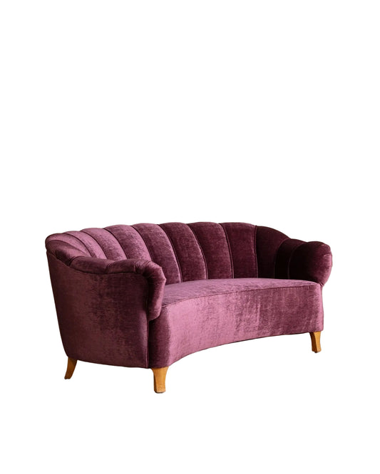 Purple sofa on a wooden floor with a beige wall background
